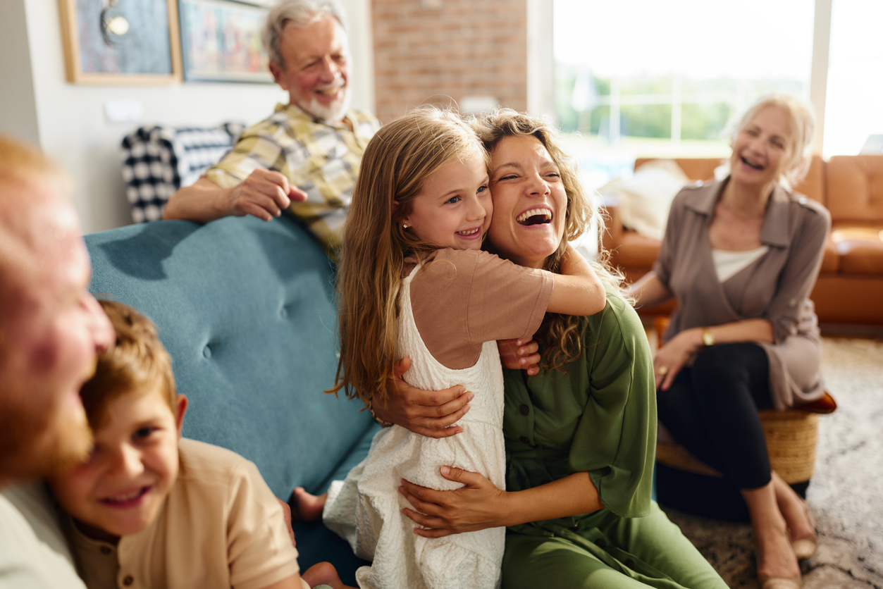 Happy mother and daughter embracing during family's time at home.