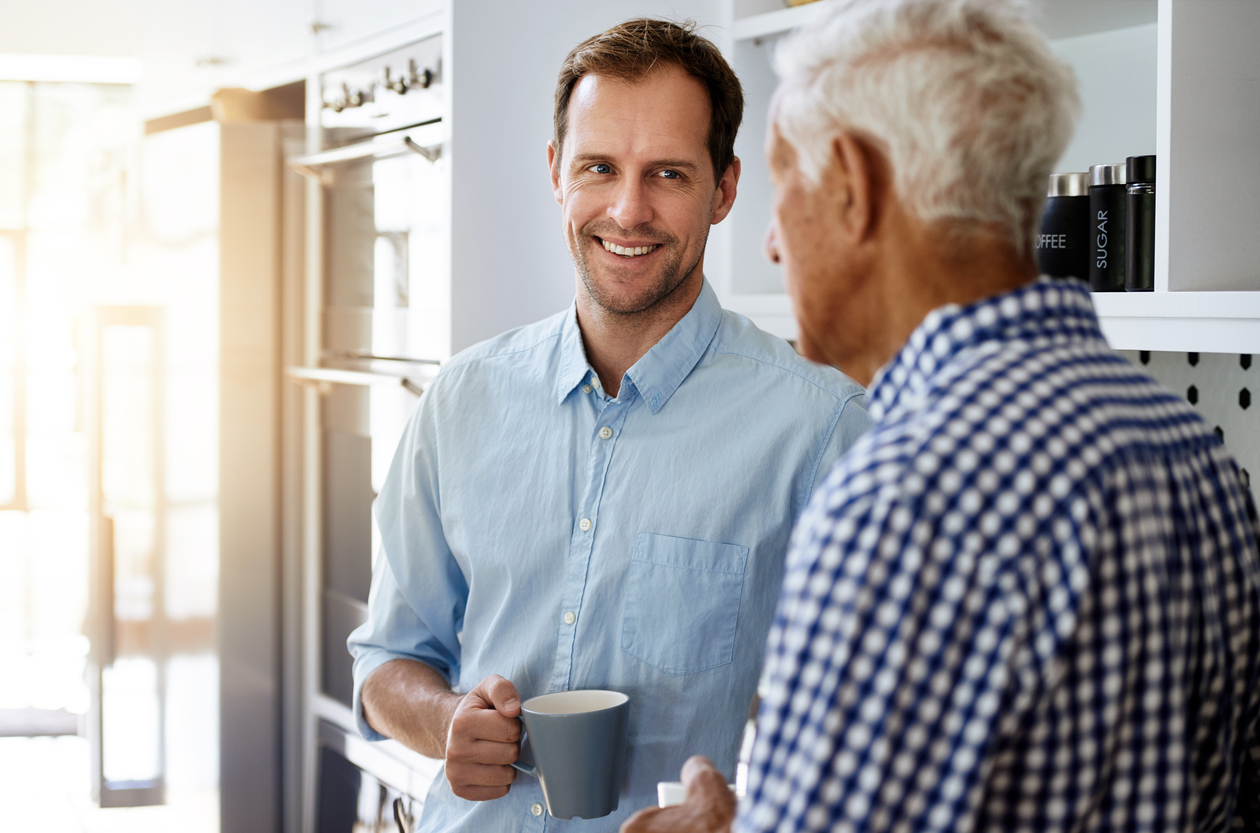 Cropped shot of a man and his elderly father drinking coffee together at home